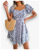 A woman displays a charming blue floral print dress from Eternal Gleams. The dress, featuring puffed short sleeves, a sweetheart neckline, and a fitted bodice with a flared skirt, offers a cool and calming style. The blue tone provides a serene and sophisticated look, making it perfect for any occasion. Paired with a gold necklace, the dress’s elegant and graceful nature shines through.