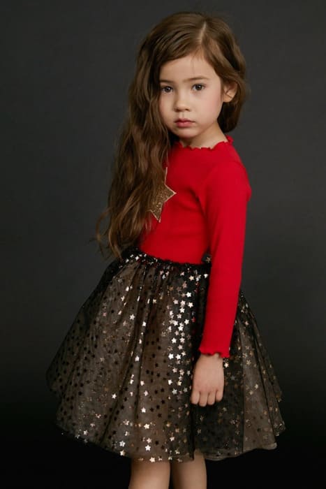 Toddler wearing a festive Christmas dress at a holiday party, from Eternal Gleams